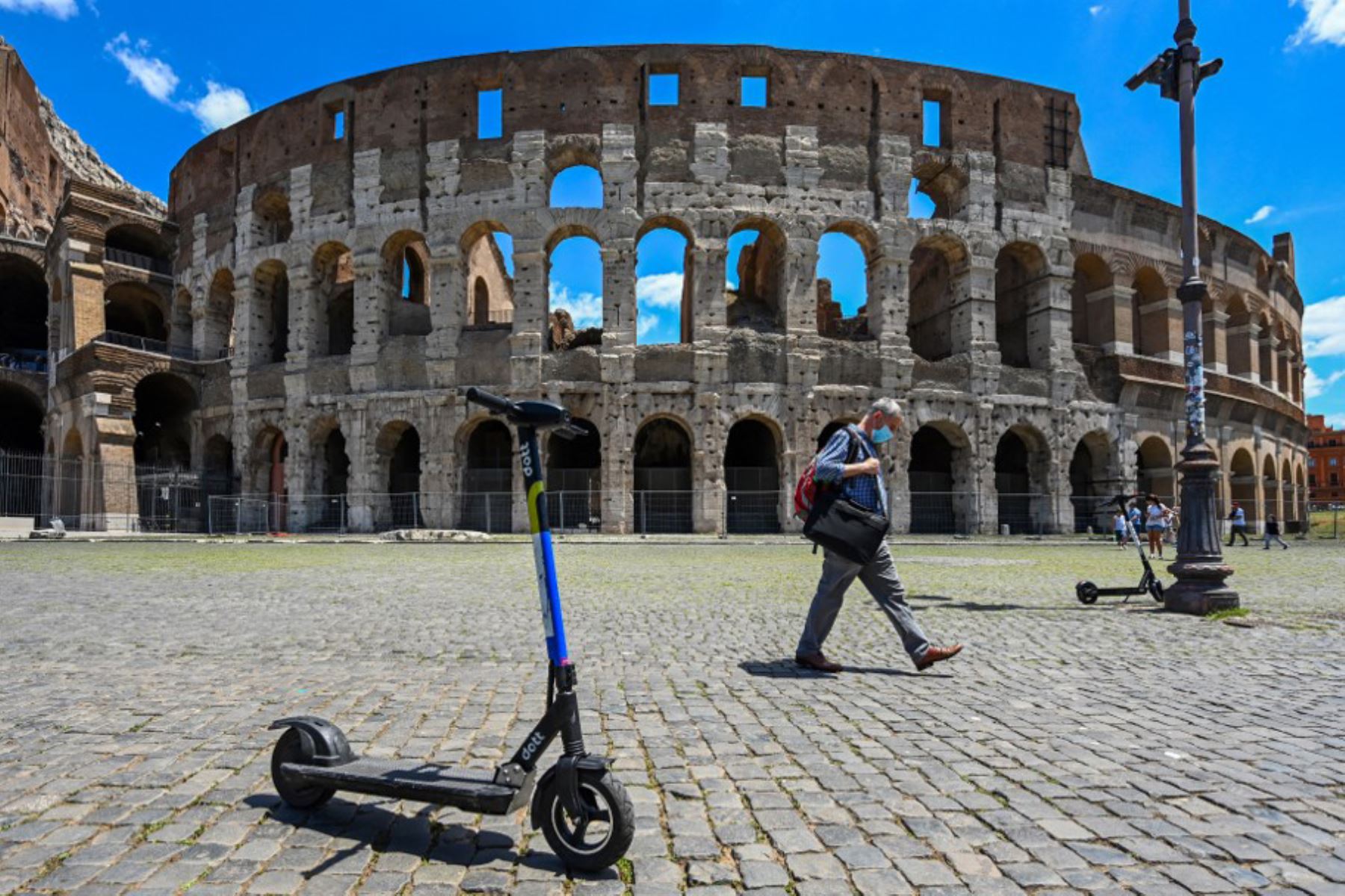 La foto muestra scooters eléctricos compartidos estacionados frente al monumento del Coliseo en Roma. Foto: AFP
