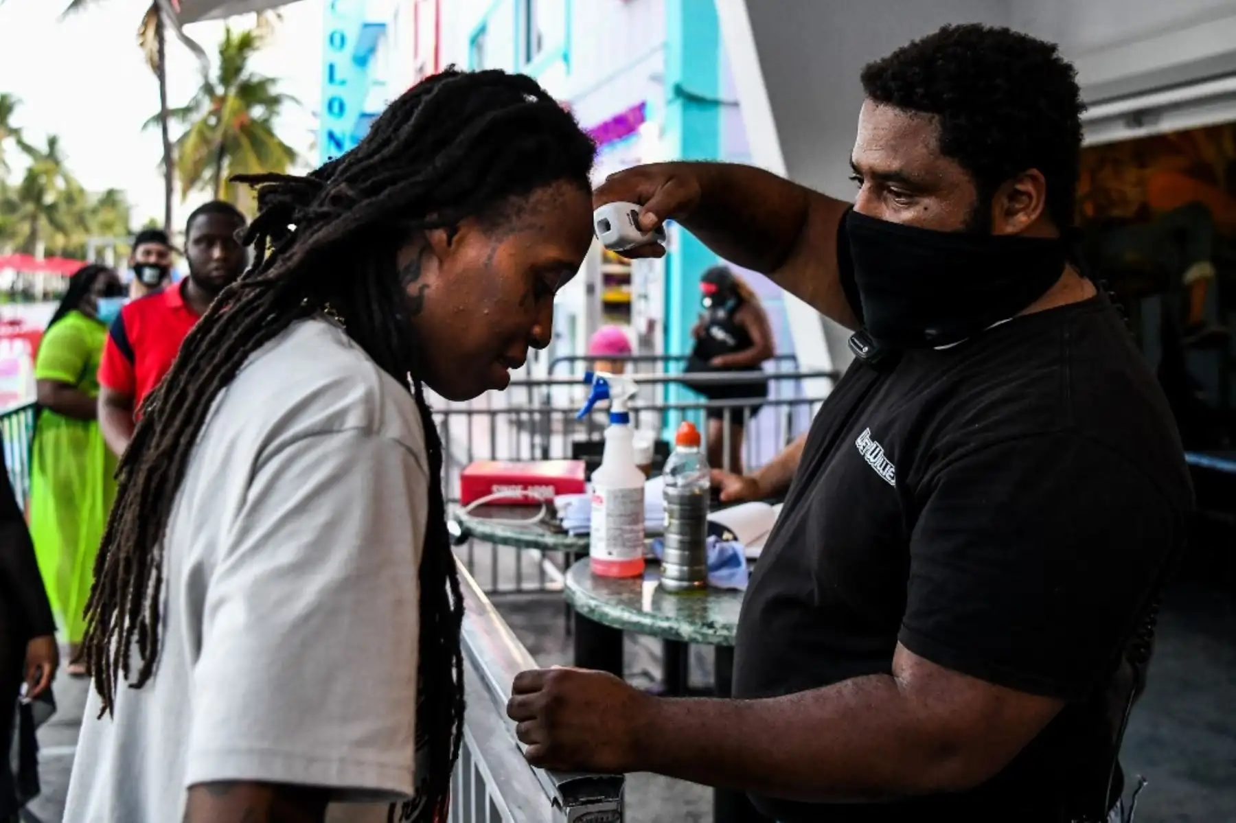 Un guardia de seguridad verifica la temperatura de un hombre a la entrada de un restaurante en Ocean Drive en Miami Beach, Florida. Foto: AFP