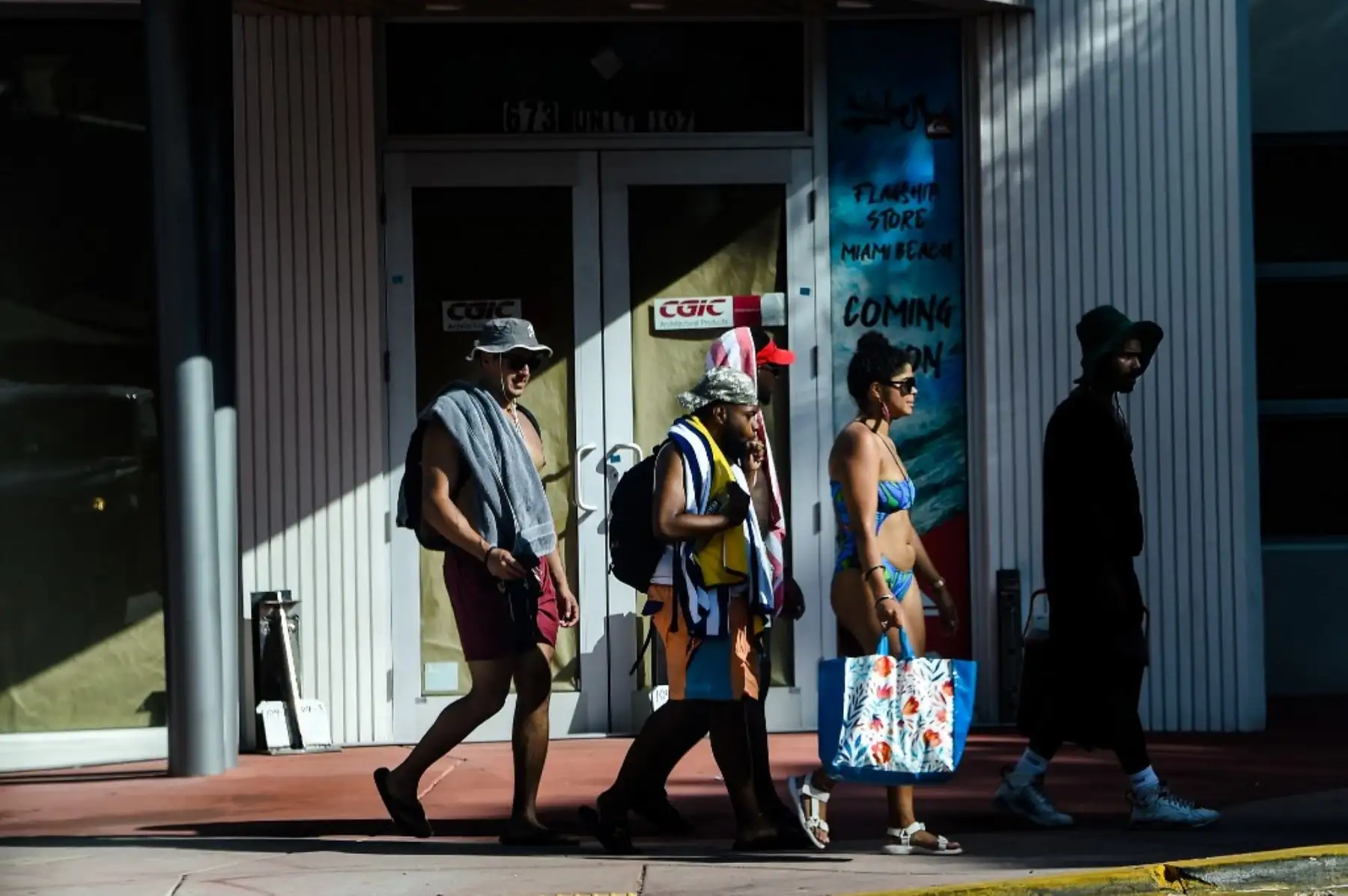 La gente camina de regreso de la playa en Miami Beach, Florida. Foto: AFP