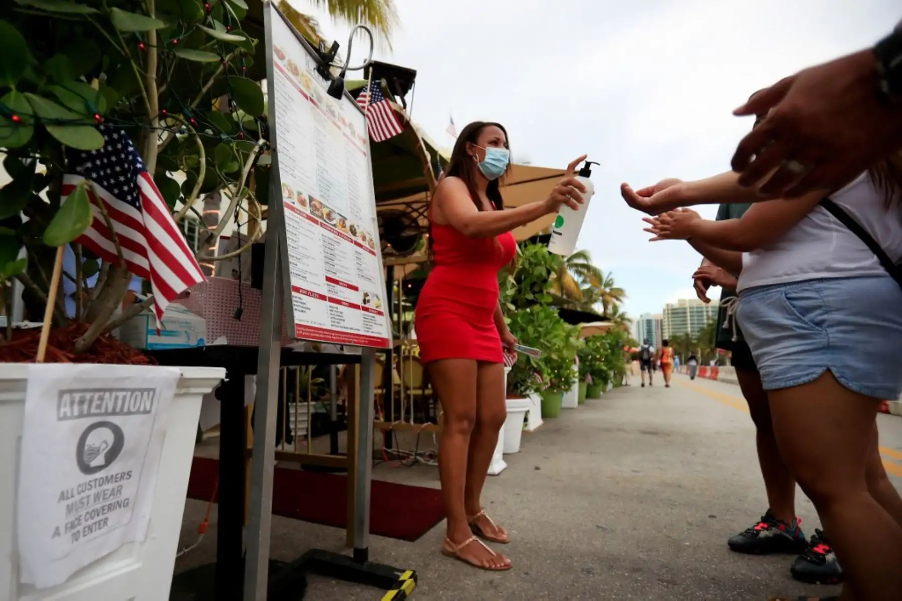 Una anfitriona proporciona desinfectante para manos a los clientes que ingresan a un restaurante en el vecindario de South Beach en Miami Beach, Florida. Foto: AFP