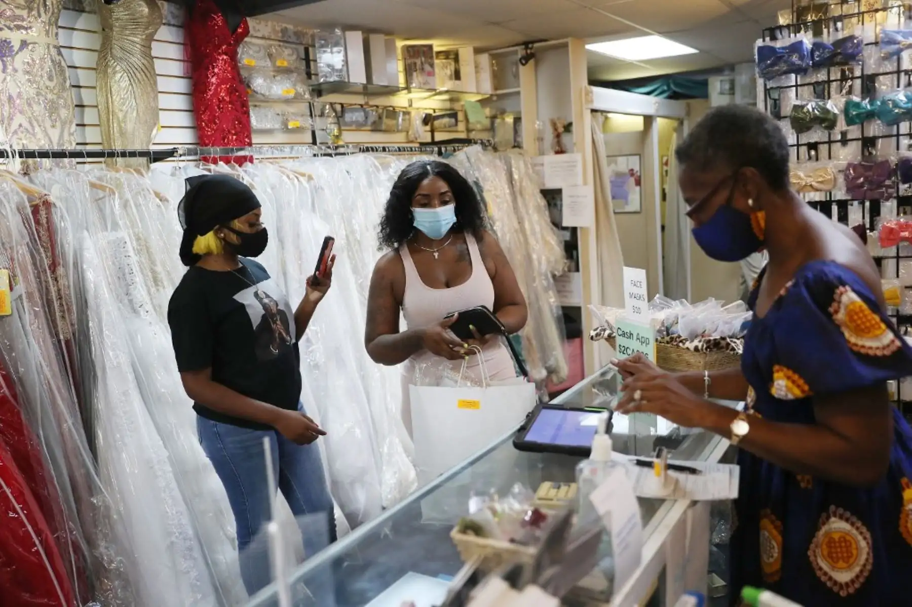 Perlina Robinson vende un vestido a Daijah Pearson y su madre Artrice Johnson en la tienda The Formalwear en Blackout Day 2020 en Miami Gardens, Florida. Foto: AFP