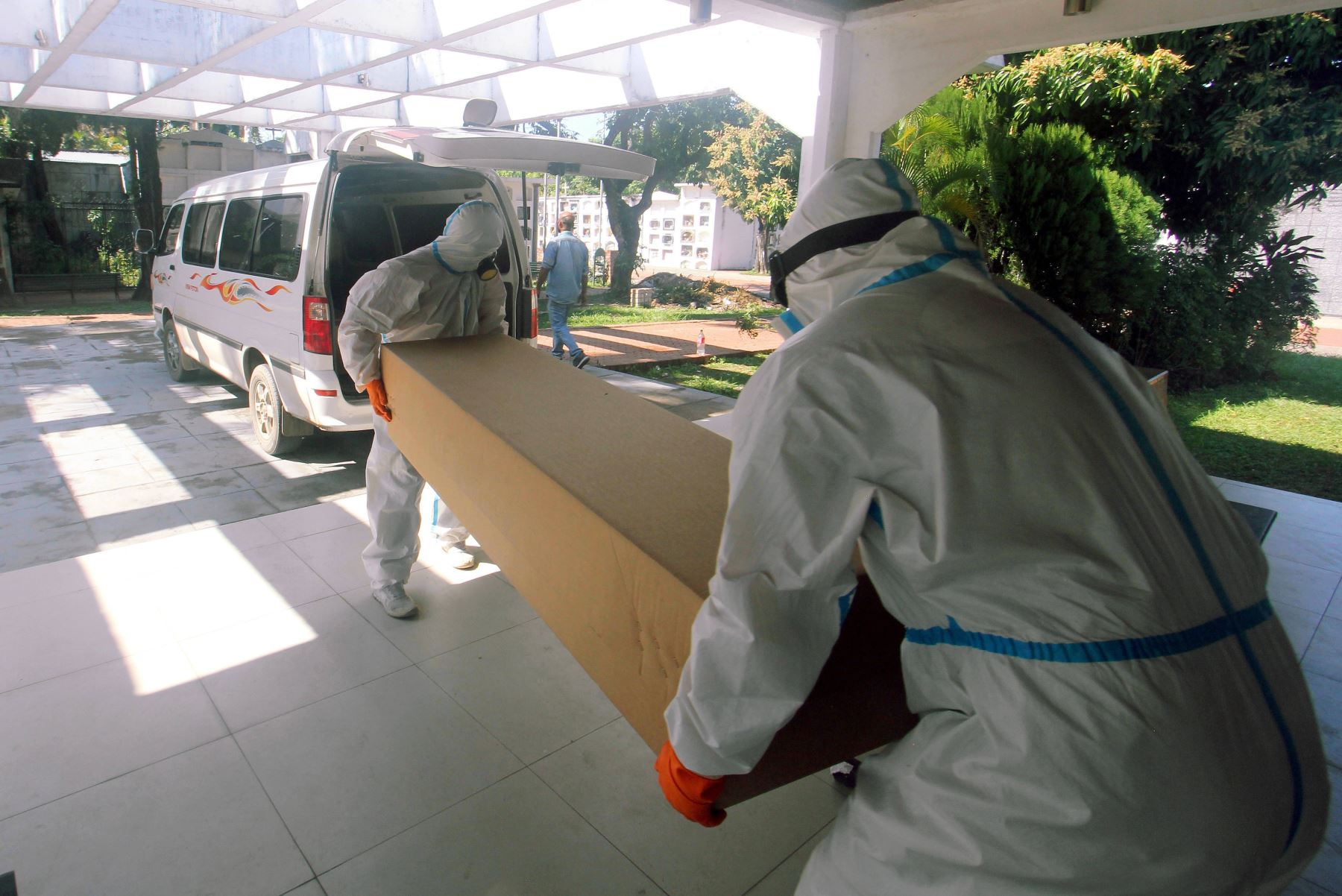 Funcionarios de la Alcaldía de Santa Cruz cargan un ataúd de cartón hacía un vehículo, el pasado 15 de julio, en Santa Cruz (Bolivia). Foto: EFE