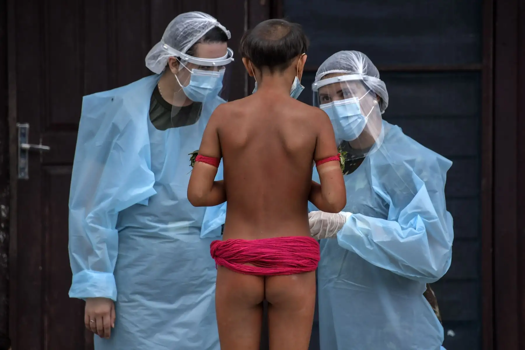 Miembros del equipo médico de las Fuerzas Armadas de Brasil hablan con un miembro del grupo étnico yanomami en un pelotón fronterizo especial, donde se realizan pruebas para covid-19, en la tierra indígena de Surucucu , en Alto Alegre, estado de Roraima, Brasil. Foto: AFP