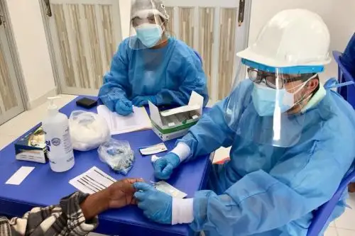 Personal de salud toma una muestra de sangre para descartar covid-19 en un adulto mayor albergado en el asilo San José.