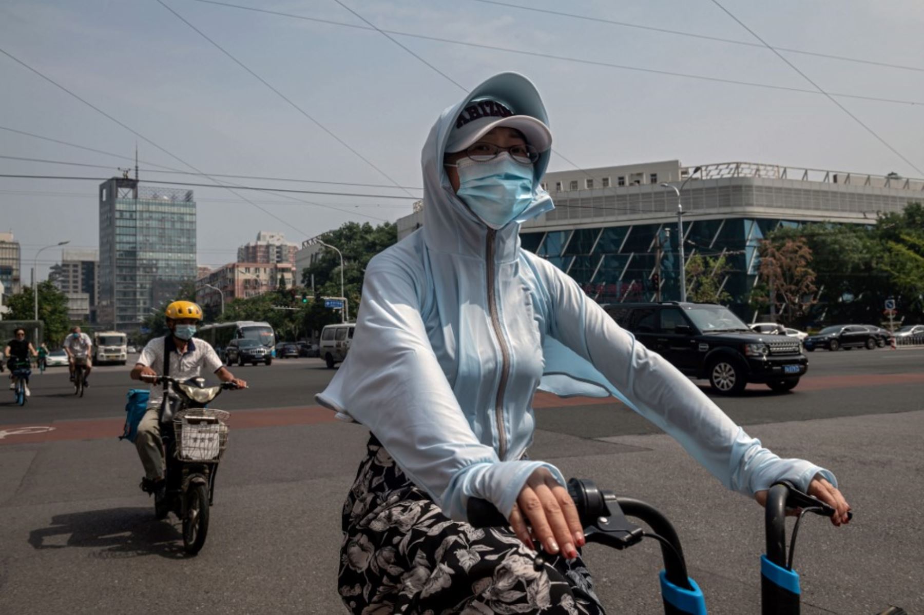Una mujer monta una bicicleta compartida en una calle en Beijing. Foto: AFP