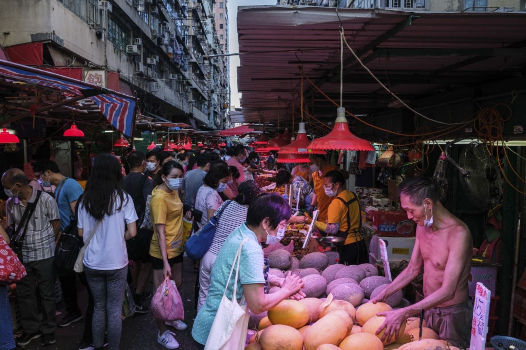La gente compra frutas y verduras en un mercado callejero en Hong Kong. Foto: AFP
