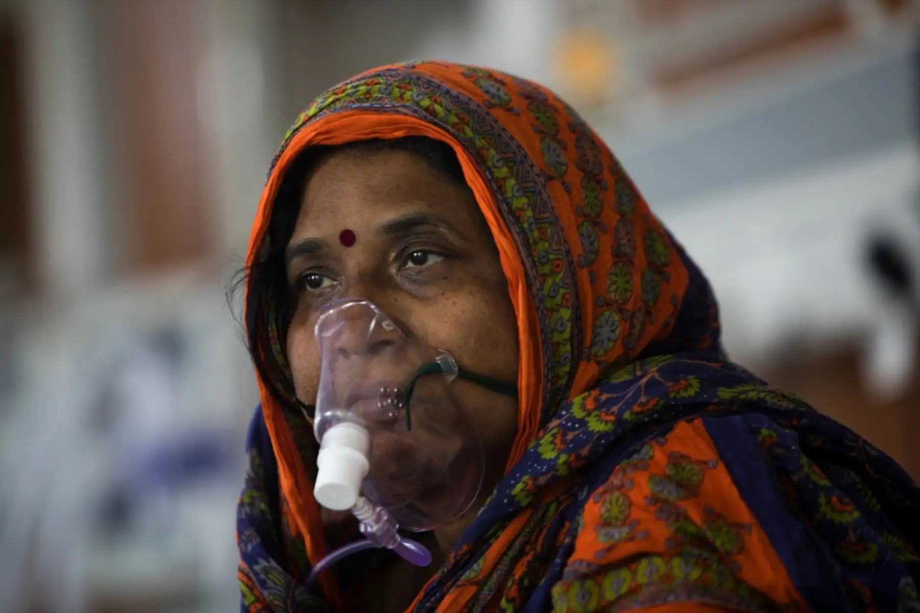 Una paciente con coronavirus covid-19 se sienta en su cama en la Unidad de Cuidados Intensivos del Hospital Sharda, en la India. Foto: AFP