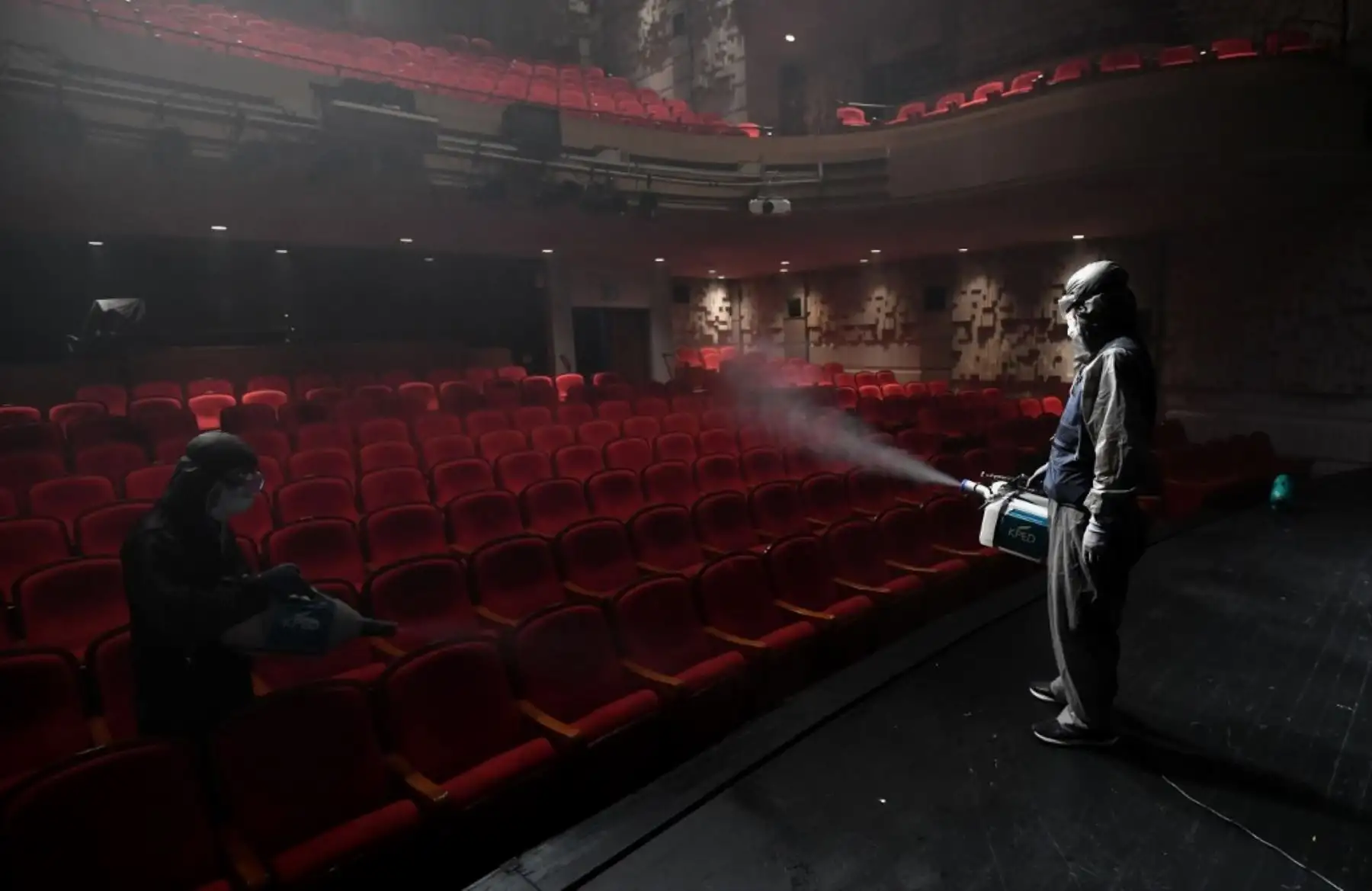 Un trabajador surcoreano que viste ropas protectoras rocía desinfectante en un teatro en el Centro Sejong en Seúl. Foto: AFP