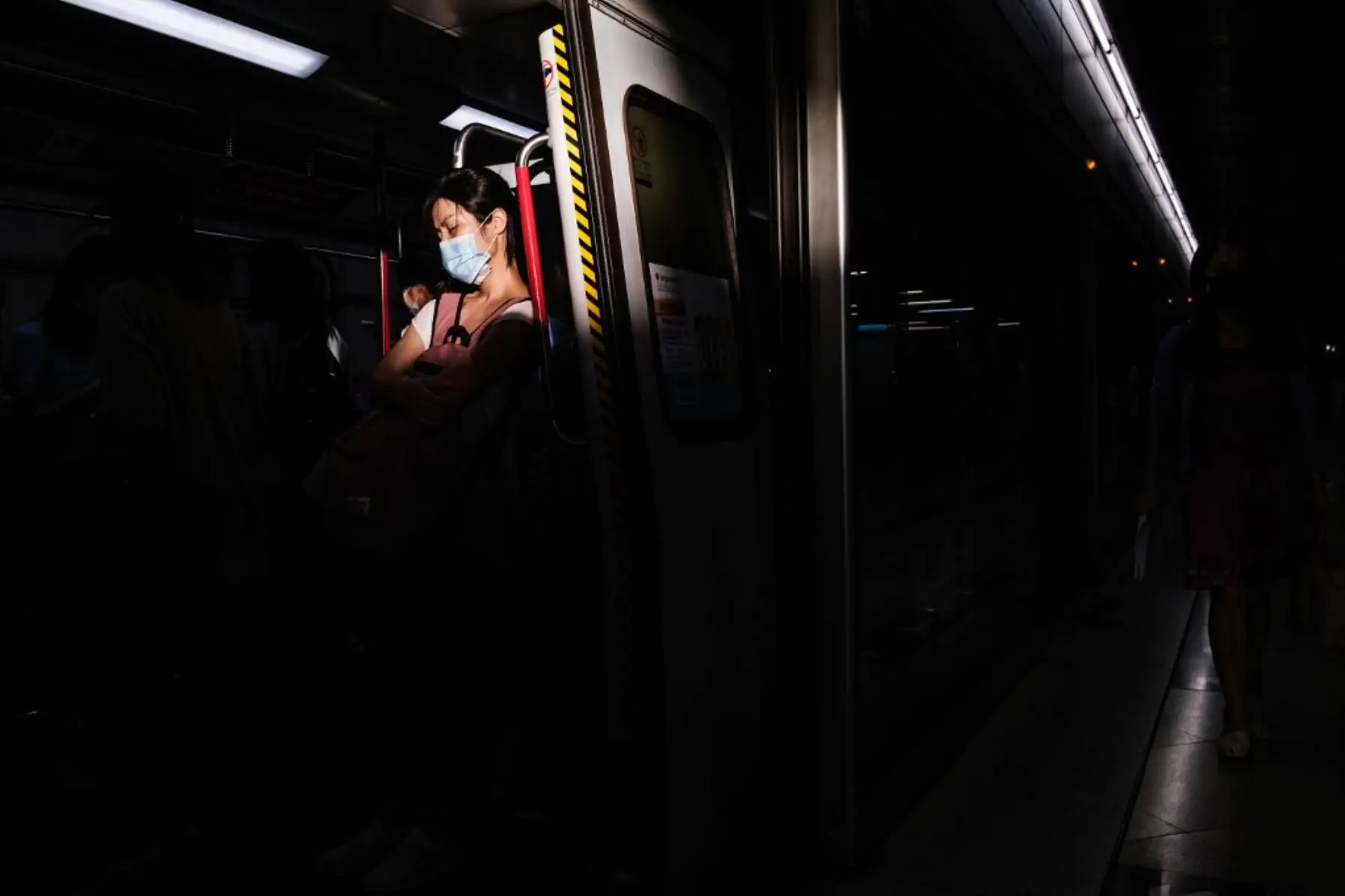 Una viajera descansa mientras está de pie en un tren de metro en Hong Kong. Foto: AFP