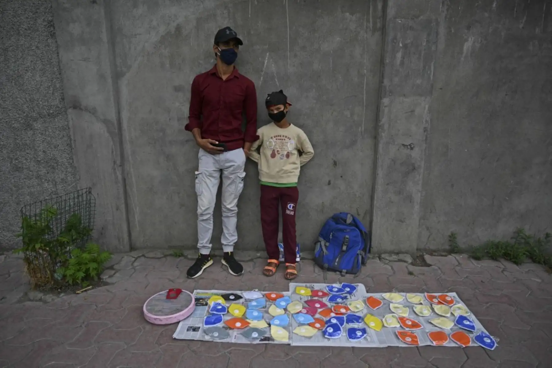 Un hombre vende máscaras faciales junto a su hijo en Srinagar, India. Foto: AFP