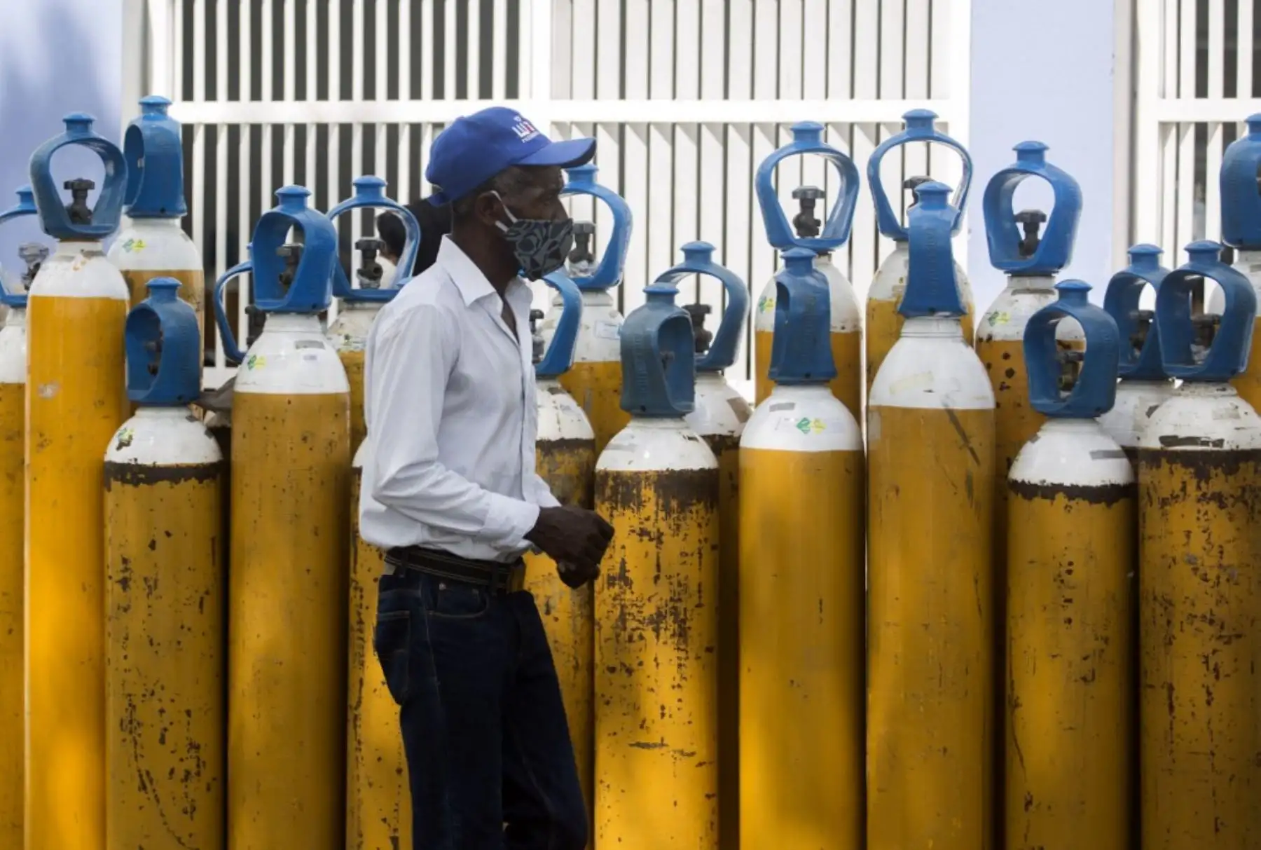 Un hombre pasa junto a unos cilindros de oxígeno fuera de la sala covid-19 del Hospital Moscoso Puello en Santo Domingo, República Dominicana. Foto: AFP