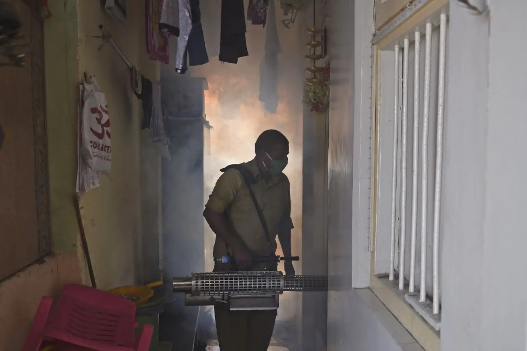 Un trabajador de la autoridad cívica fumiga un área residencial como medida preventiva contra los mosquitos portadores de enfermedades durante la temporada del monzón en Mumbai, India. Foto: AFP