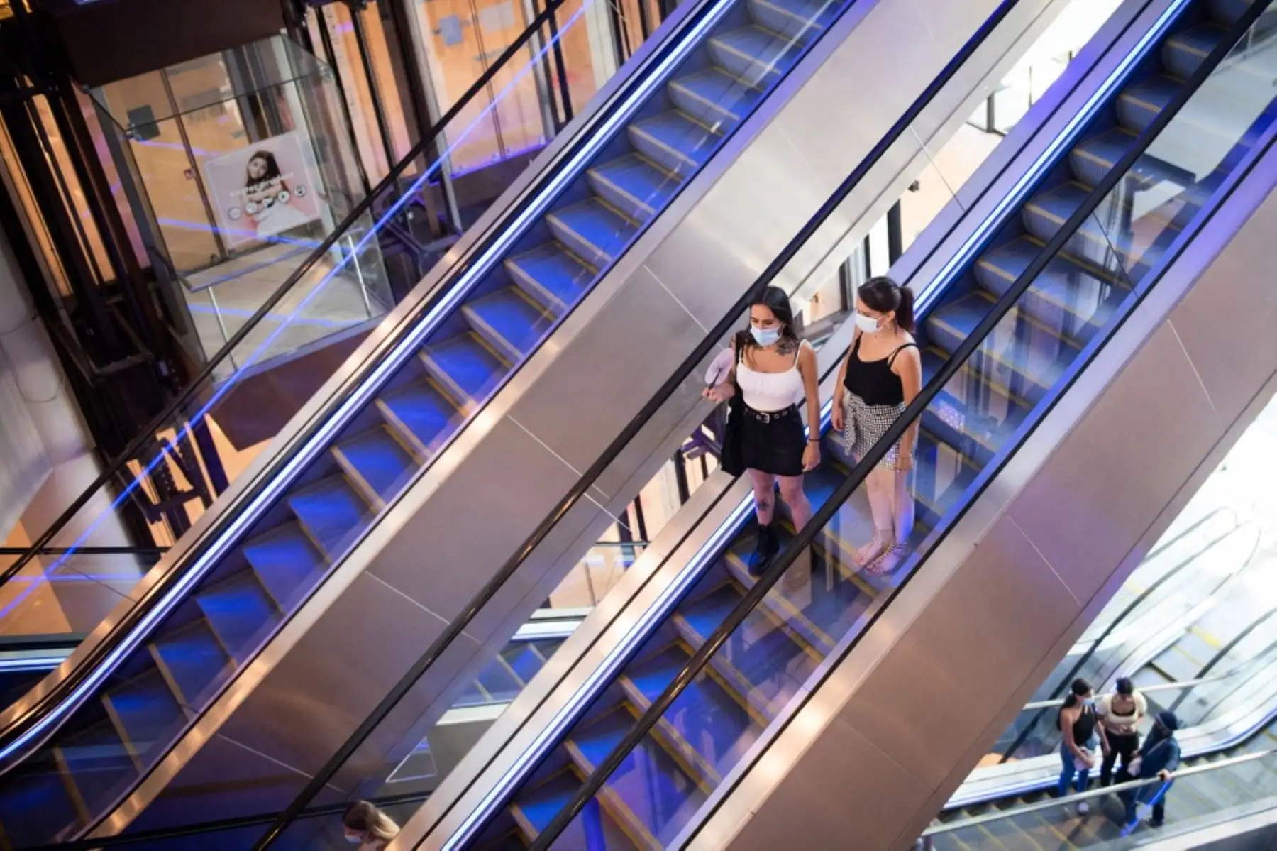 Las personas que usan máscaras protectoras debido a la pandemia de coronavirus COVID-19, se paran en las escaleras mecánicas en el centro comercial "Les Terrasses du Port" en Marsella. Foto: AFP