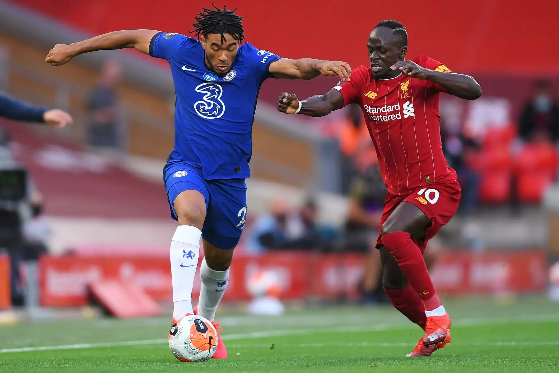El defensor inglés del Chelsea Reece James compite  el balón contra  el delantero senegalés del Liverpool Sadio Mane durante el partido de fútbol de la Premier League. Foto: AFP