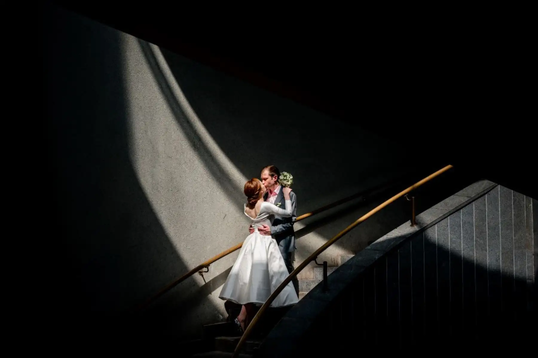 Una pareja de recién casados se besa en las escaleras del Puente Andreyevsky en Moscú. Foto: AFP