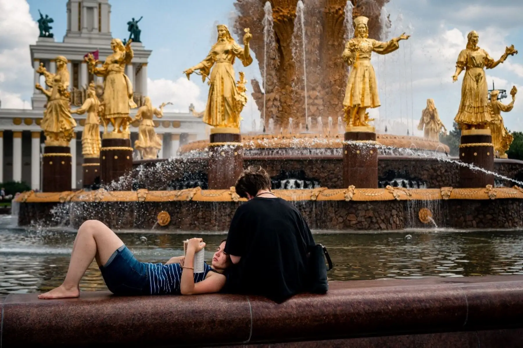 Una mujer lee un libro frente a la famosa fuente Druzhba Narodov en el Centro de Exposiciones de Toda Rusia, una feria y parque de atracciones en Moscú. Foto: AFP