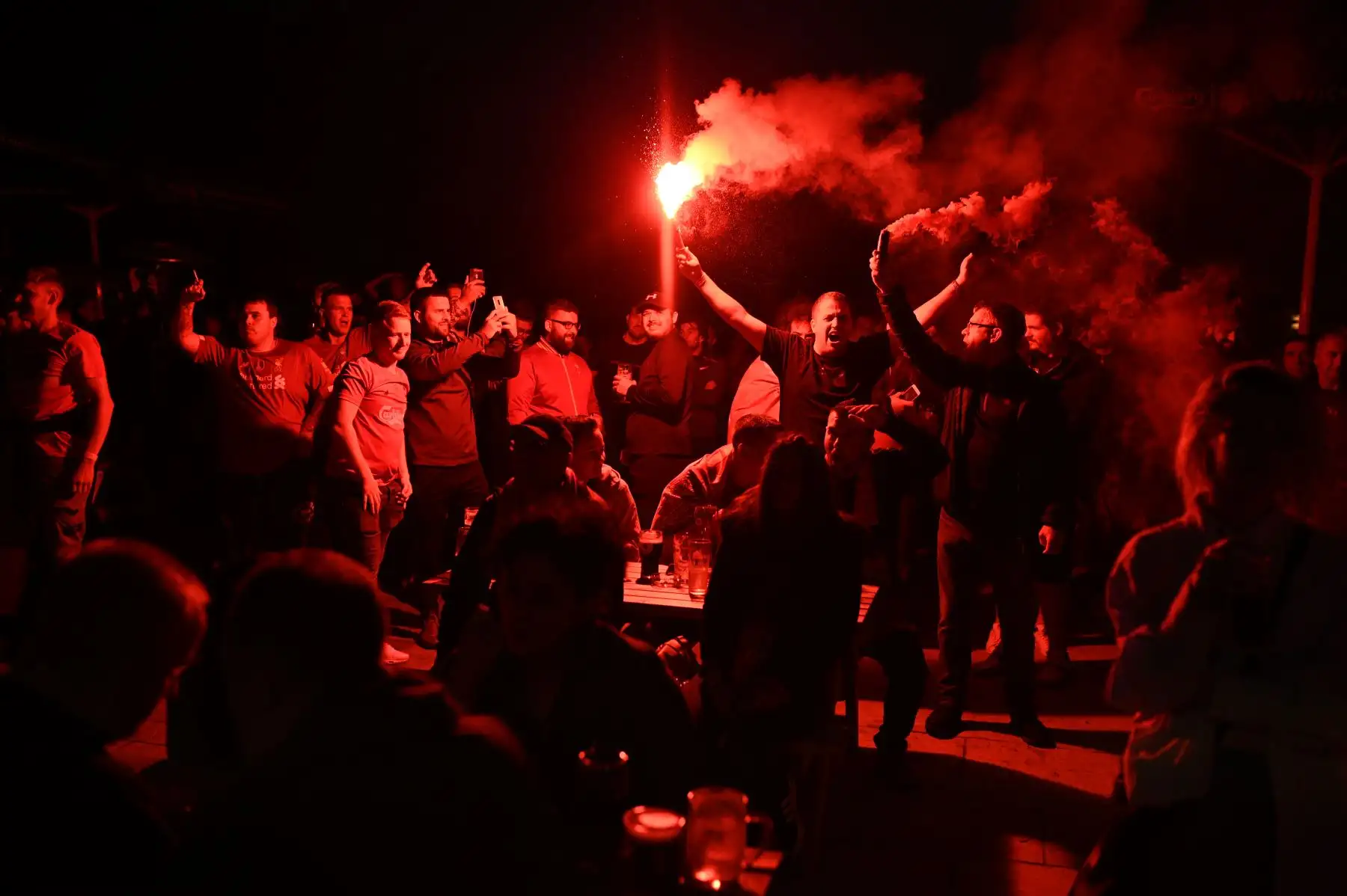 Los hinchas del Liverpool celebran mientras observan una pantalla grande que trasmite el partido de fútbol contra Chelsea por la Premier League. Foto: AFP