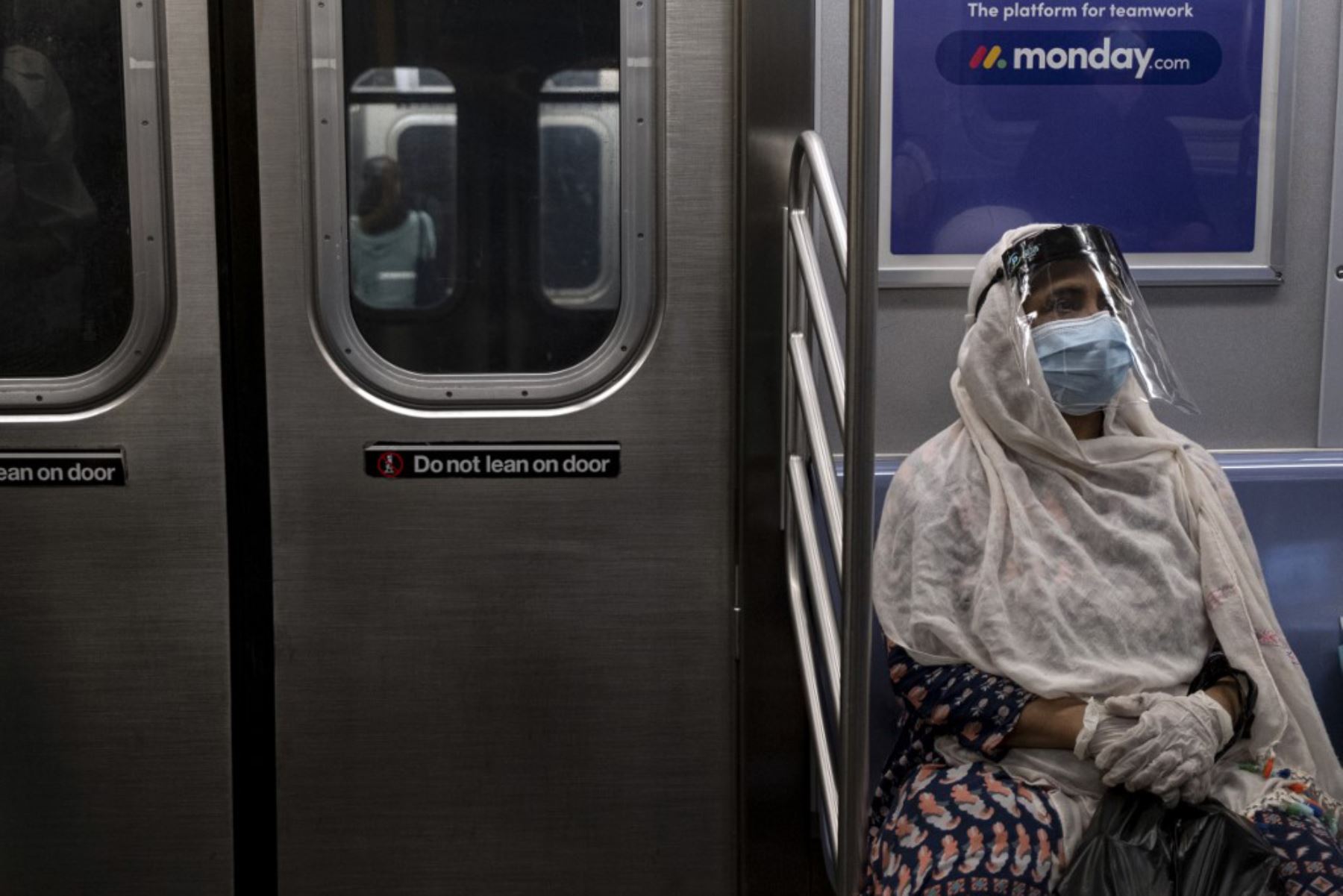 Una mujer con una máscara facial y un escudo se sienta en un tren subterráneo durante la hora pico en medio de la pandemia de coronavirus  Nueva York.Foto:AFP