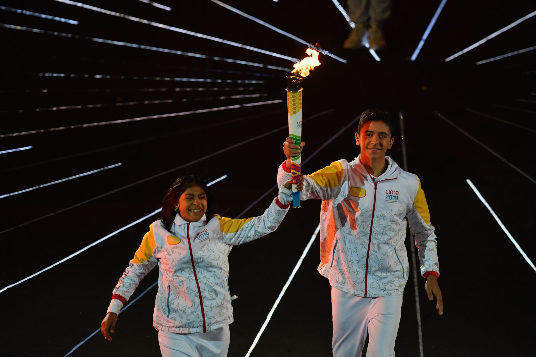 Los jóvenes atletas llevan la llama durante la ceremonia de apertura de los Juegos Panamericanos de Lima 2019 en el Estadio Nacional de Lima.
Foto: AFP