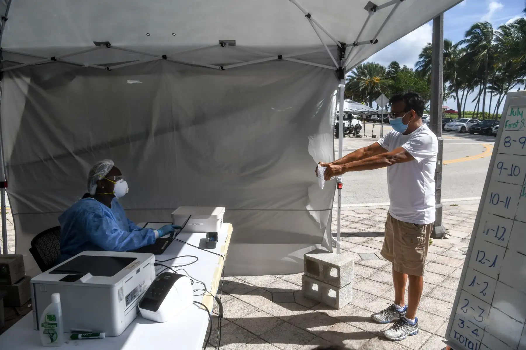 Un hombre muestra sus formularios al personal médico antes de su prueba en el camión móvil de pruebas Covid-19, en Miami Beach. Foto: AFP