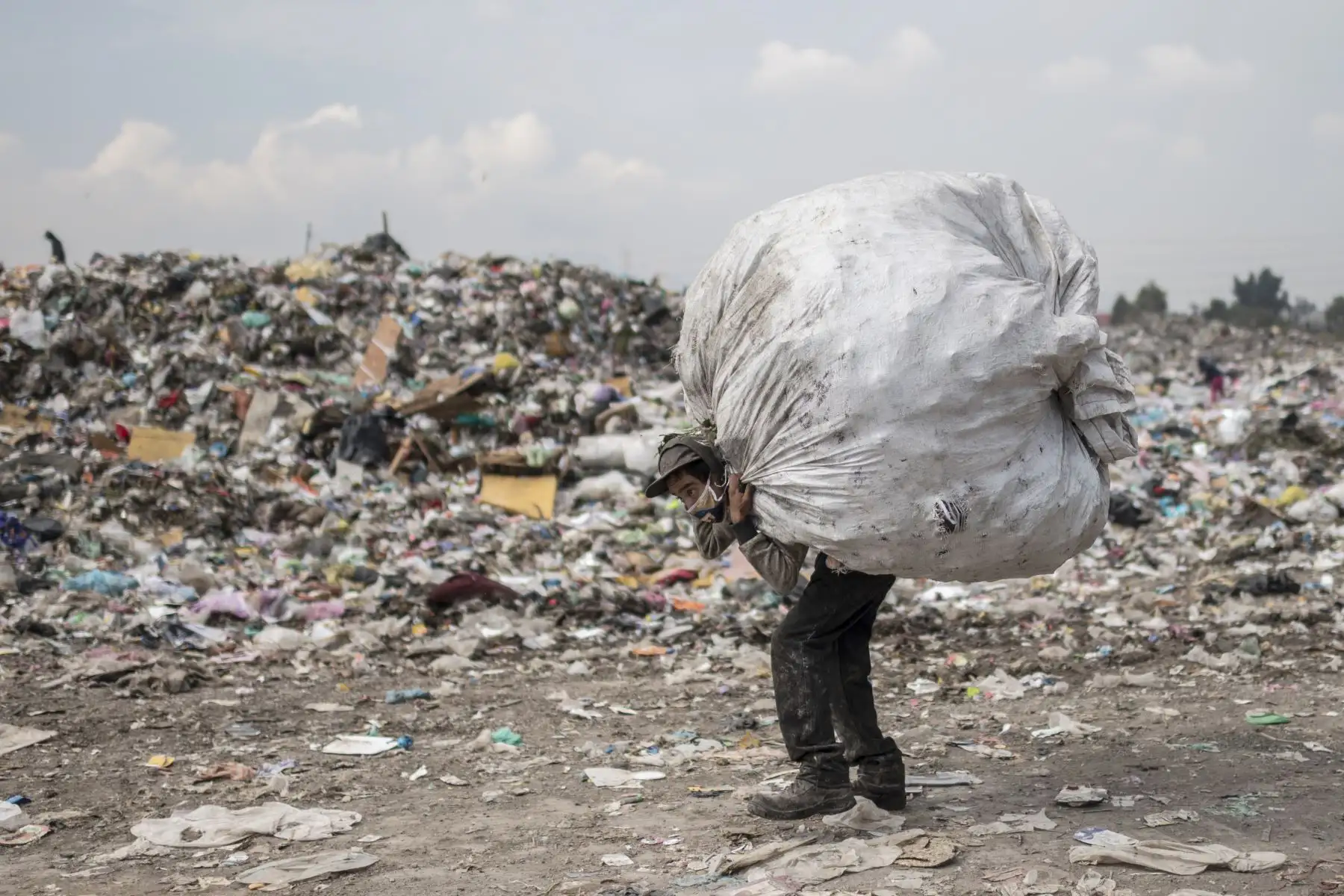 Un recolector de basura lleva una bolsa en el depósito de "Bordo de Xochiaca" en Ciudad Nezahualcóyotl, Estado de México. Foto: AFP