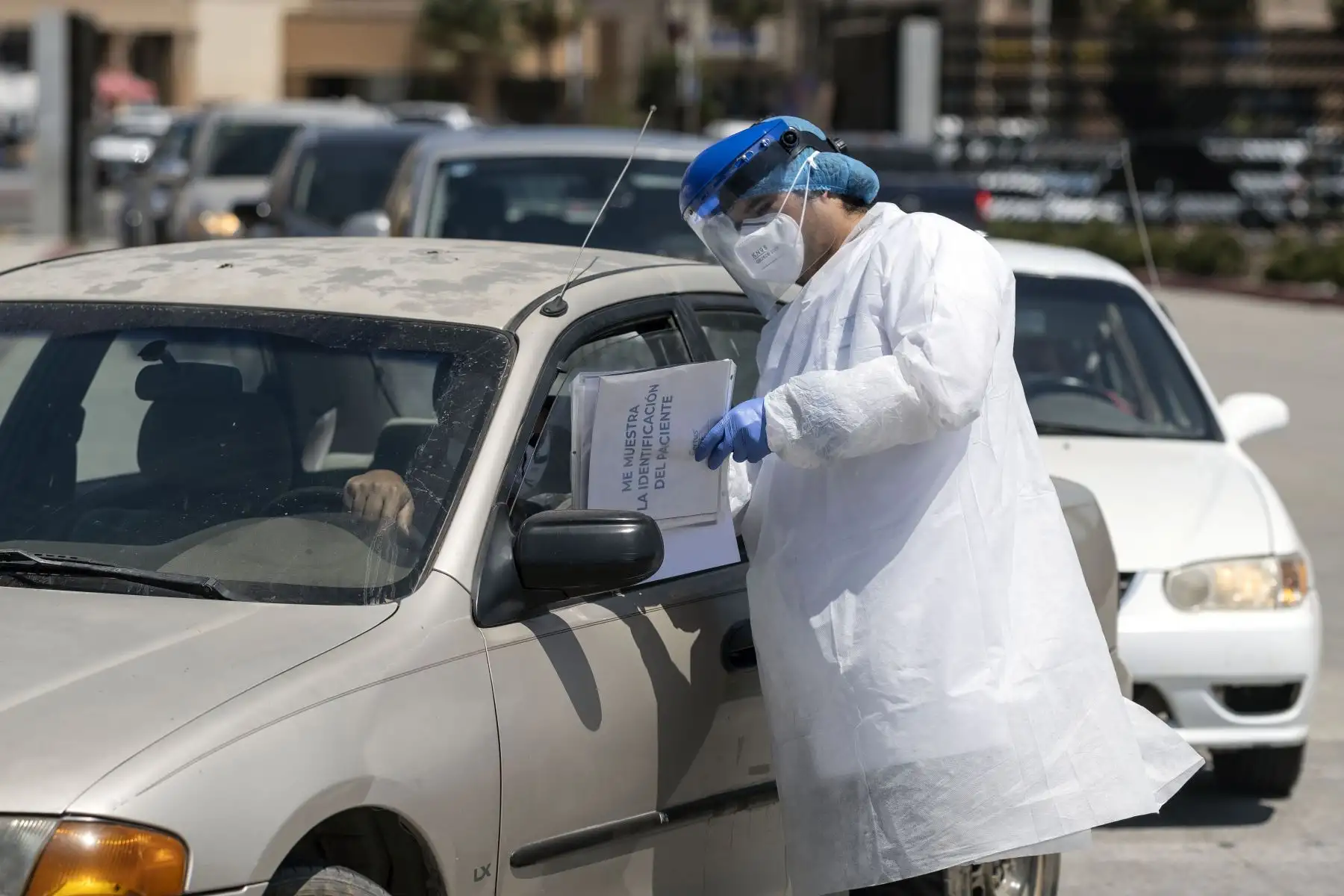 Un trabajador de laboratorio da instrucciones a los clientes en el centro de pruebas de manejo COVID-19 de Certus Lab, en Tijuana. Foto: AFP