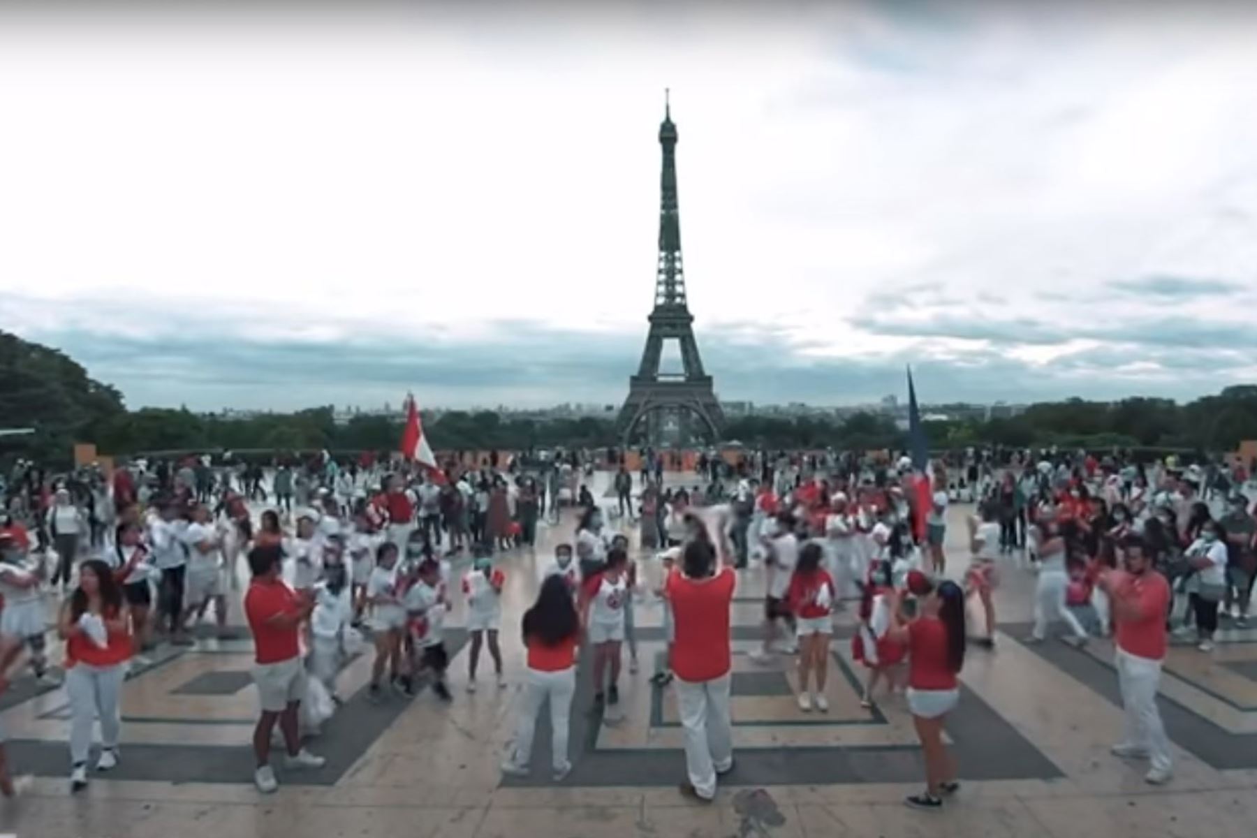 Cerca de un centenar de peruanos participaron en flashmob de marinera al pie de la Torre Eiffel, en homenaje al aniversario patrio. Foto: Captura TV