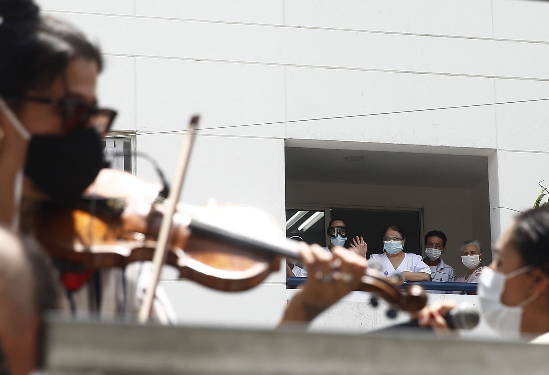 Trabajadores médicos fueron registrados al escuchar un concierto ofrecido por un grupo de músicos, frente a la Clínica León XIII, en Medellín (Colombia). Foto: EFE