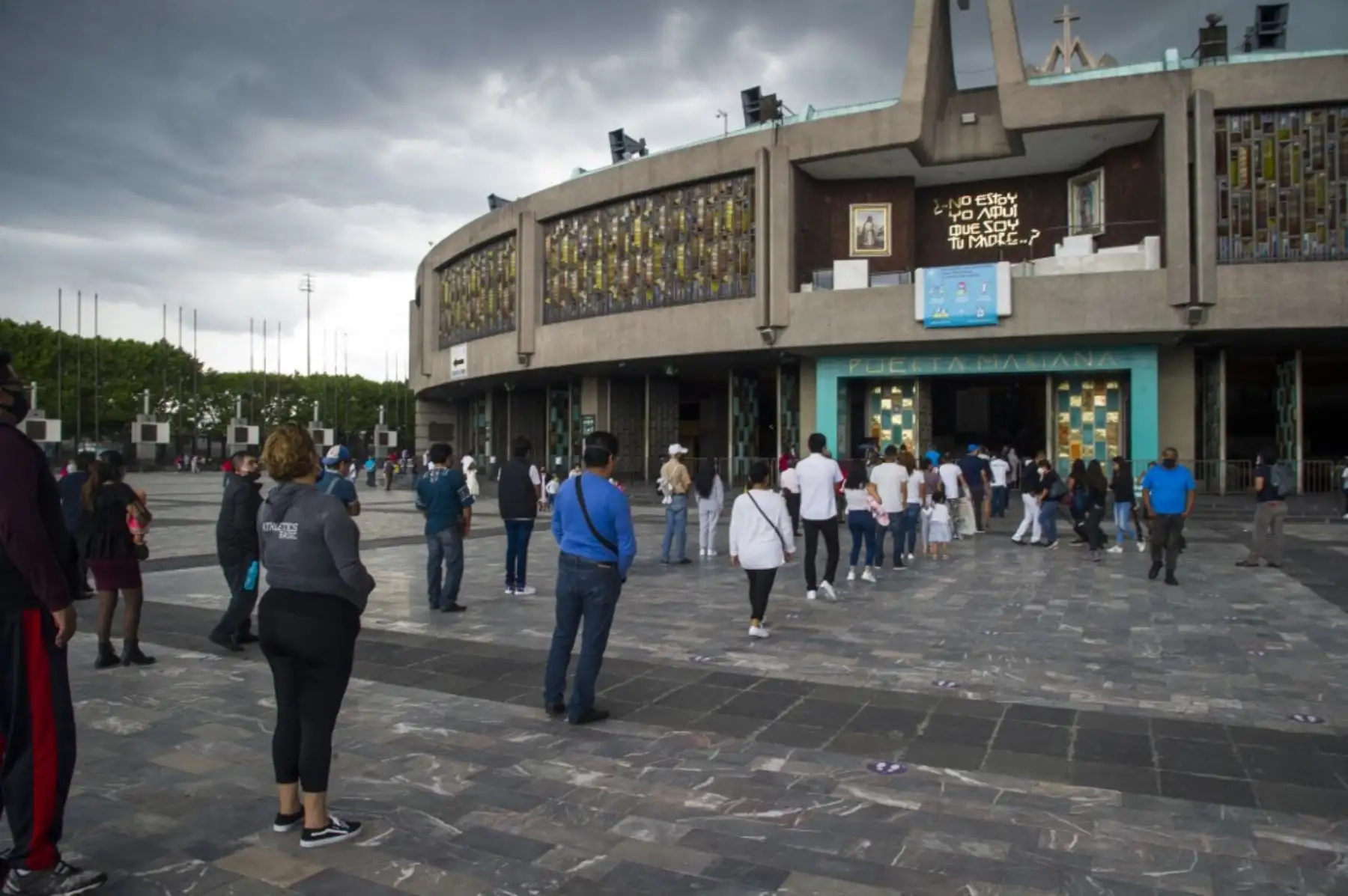 Los fieles se alinean manteniendo una distancia de seguridad mientras esperan para ingresar a la Basílica de Guadalupe. Foto: AFP