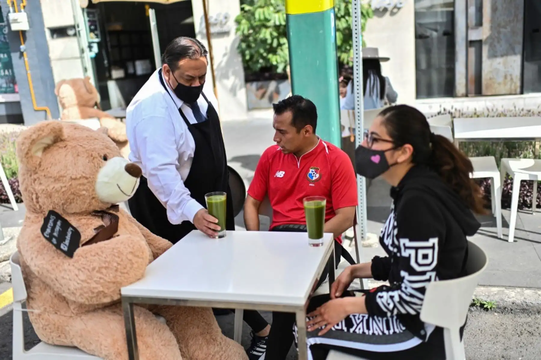Los clientes se sientan con un oso de peluche utilizado para mantener las medidas de distanciamiento social, en un restaurante en el barrio de Polanco. Foto: AFP