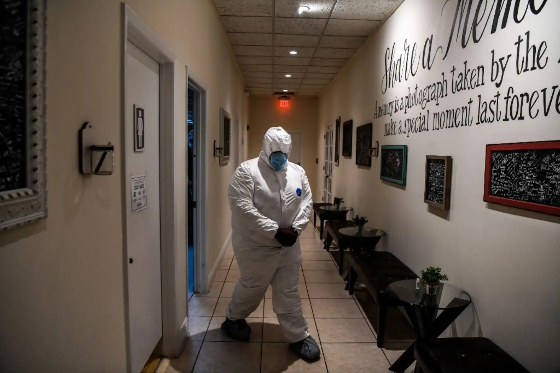 El asistente fúnebre Bradley Georges, de 26 años, camina con un equipo de protección personal antes de un funeral en una de las funerarias más grandes de Miami. Foto: AFP