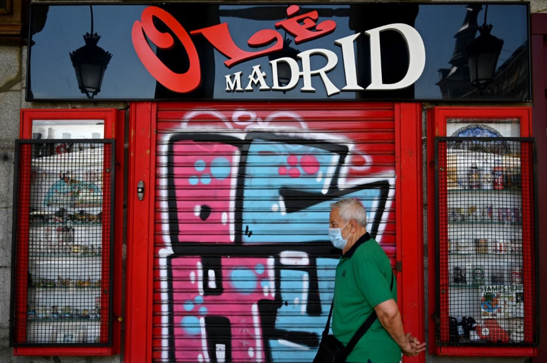 Un hombre pasa por un bar cerrado en Madrid. Foto: AFP