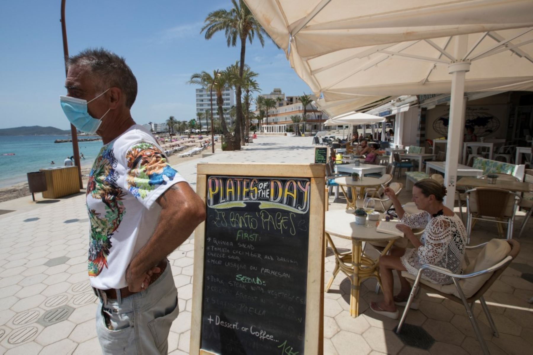 Un camarero espera a los clientes en un restaurante cerca de Playa de Figueretas. Foto: AFP