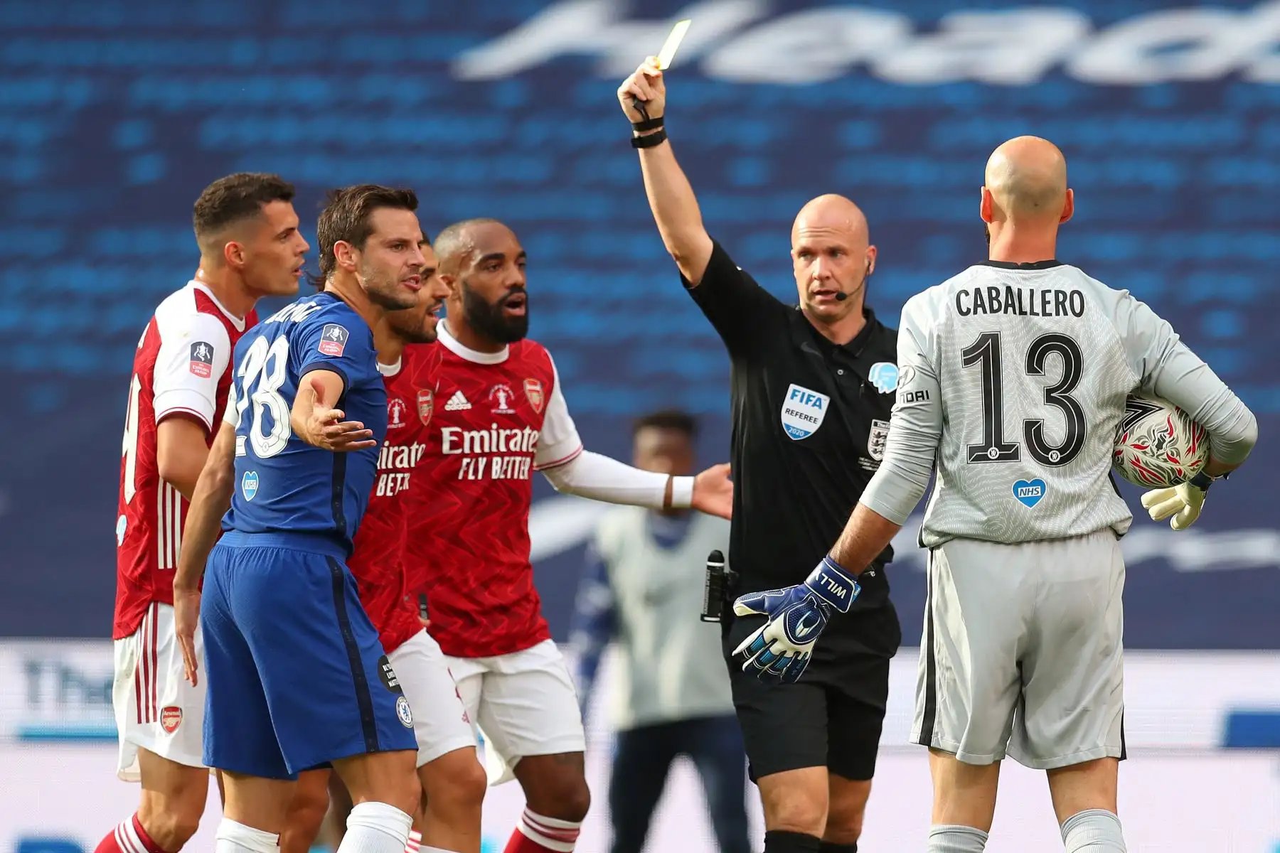El árbitro muestra una tarjeta amarilla al defensor español del Chelsea, César Azpilicueta, tras falta sobre el delantero del Arsenal, Pierre-Emerick Aubameyang,  durante el partido de fútbol final de la Copa FA inglesa entre el Arsenal y el Chelsea en el estadio Wembley, en Londres. Foto: AFP