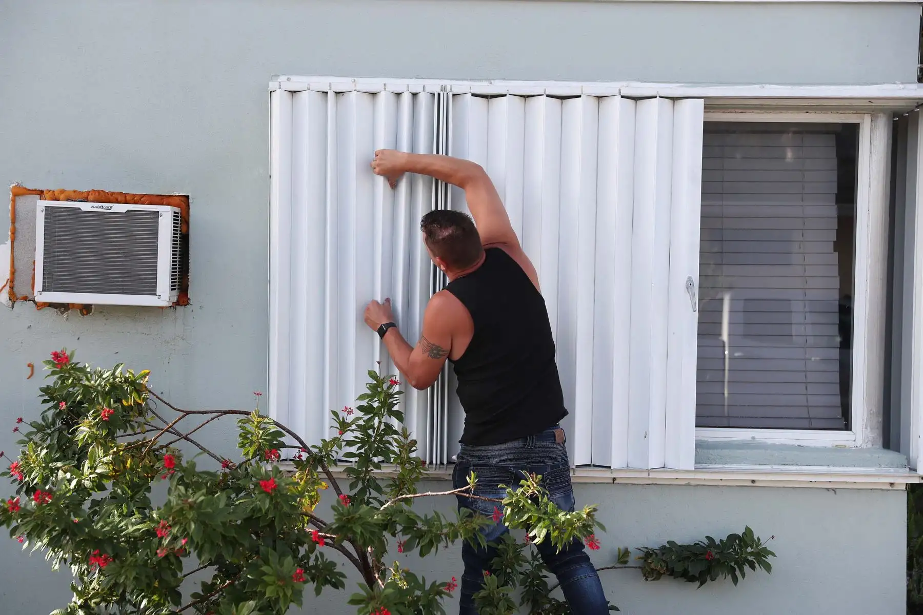 Un hombre protege las ventanas de su vivienda en Lake Worth, Florida, ante el paso del huracán Isaías. Foto: AFP