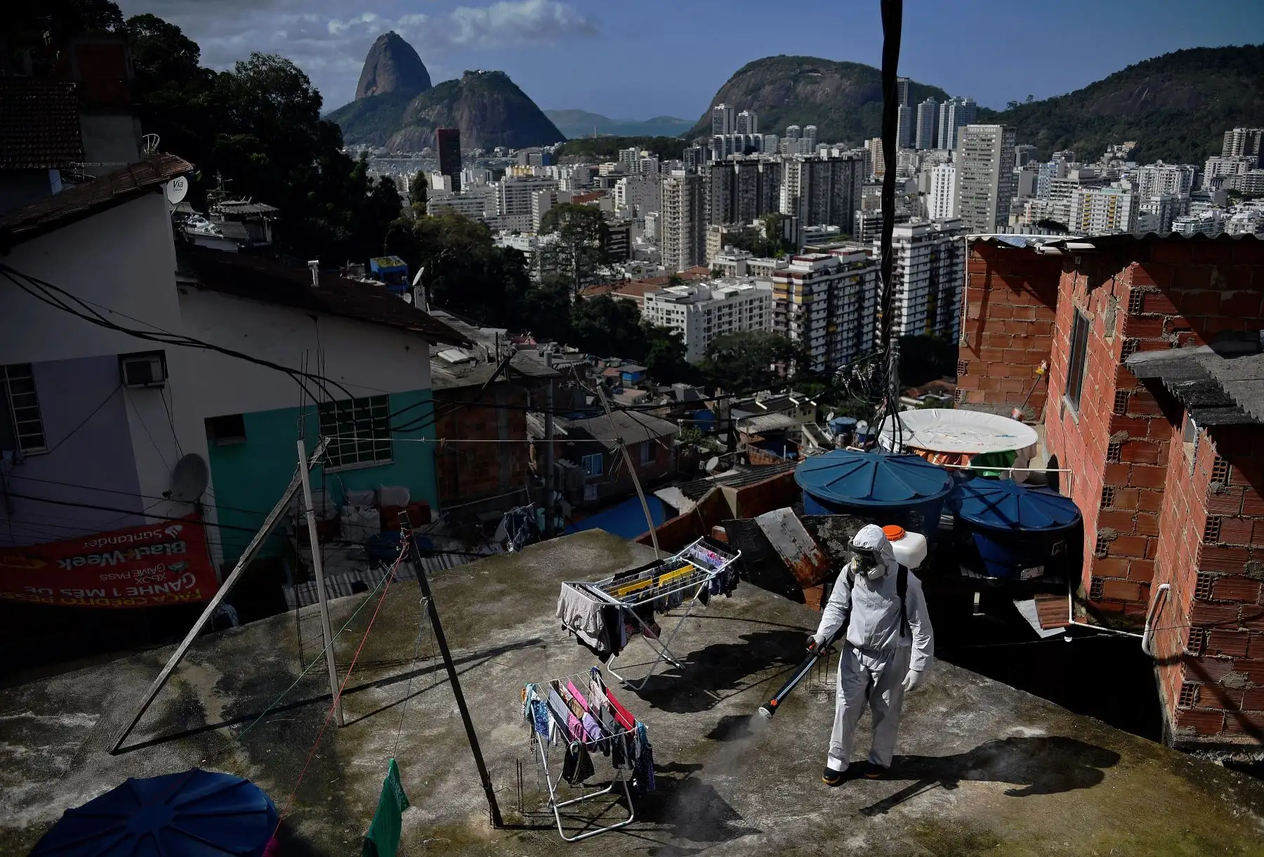 Un voluntario desinfecta un área de la azotea dentro de Santa Marta Favela, en Río de Janeiro, Brasil. Foto: AFP