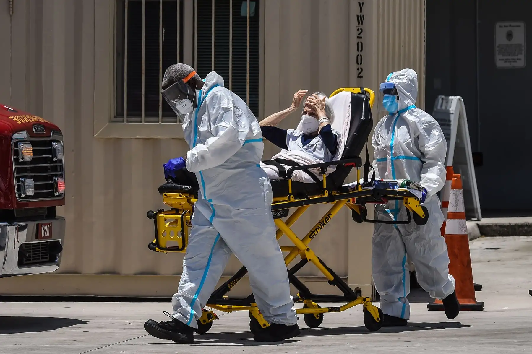 Los médicos transfieren a un paciente en una camilla desde una ambulancia afuera de Emergencia en el Hospital Coral Gables, cerca a Miami. Foto: AFP
