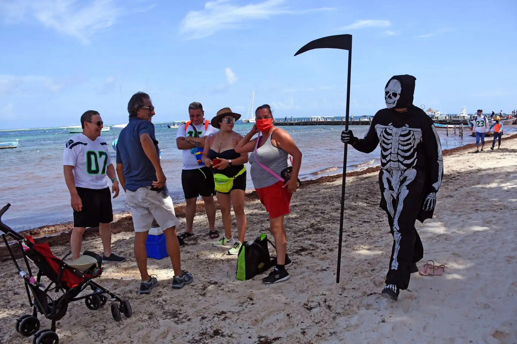 Un joven representa a la muerte invitando a turistas y lugareños a regresar a sus hogares ya que las playas  de México aún están cerradas para los visitantes debido a la pandemia. Foto: AFP