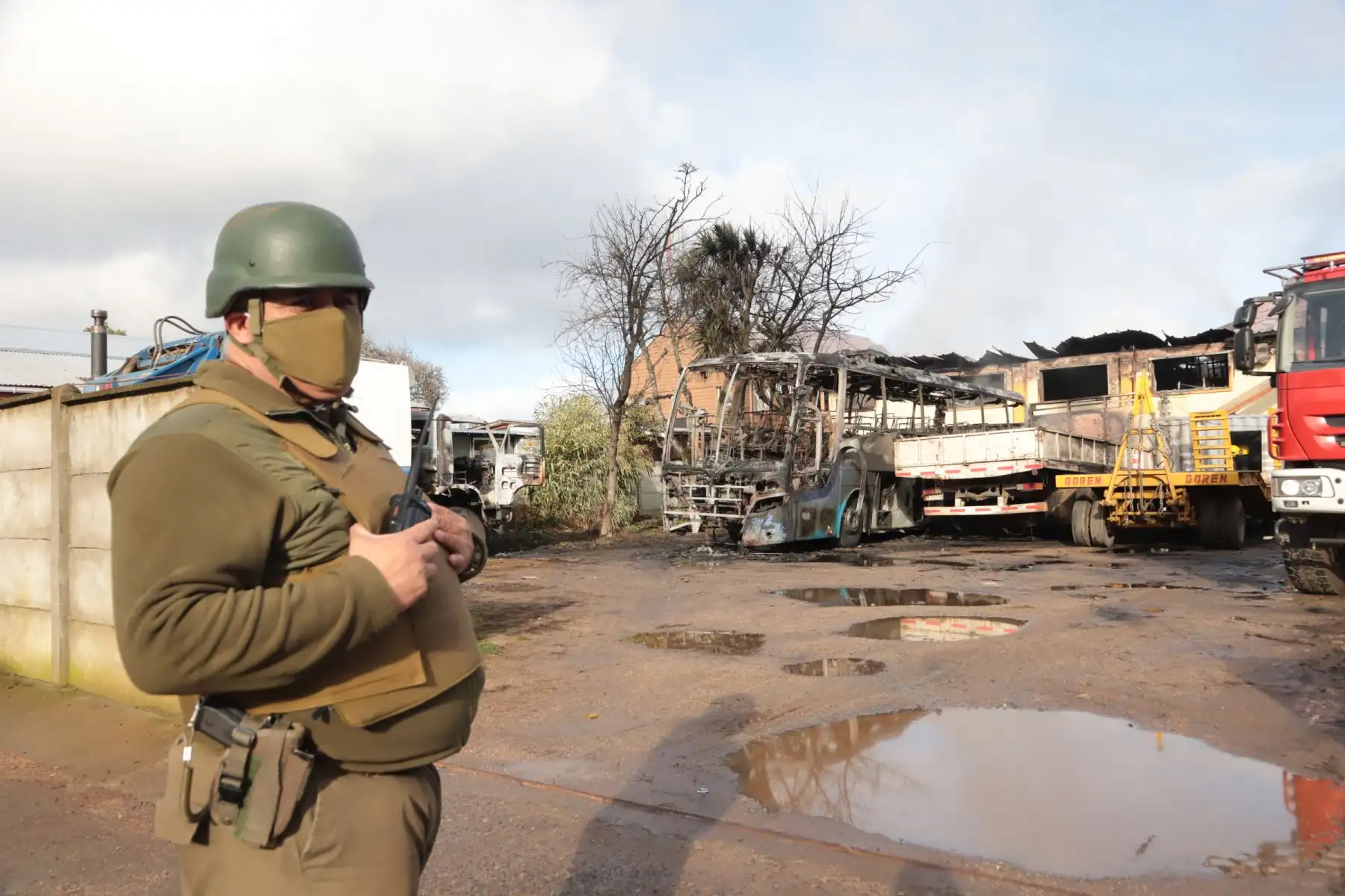 Un guardia de policía junto a vehículos incendiados frente al municipio de Ercilla, región de la Araucanía, sur de Chile. Foto: AFP