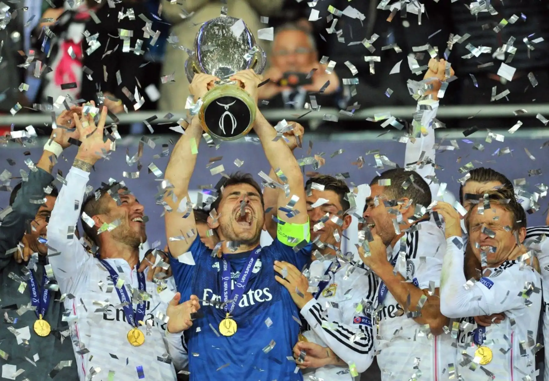 El portero del Real Madrid, Iker Casillas, levanta el trofeo mientras los jugadores del Real Madrid celebran después del partido de fútbol de la Supercopa de la UEFA entre el Real Madrid y el Sevilla. Foto: AFP