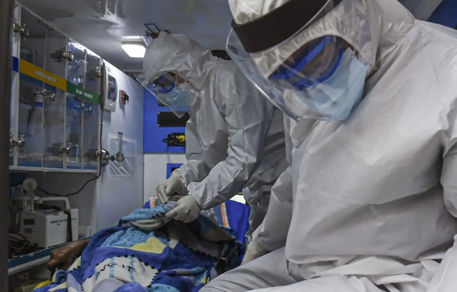 Los trabajadores de la salud atienden a un paciente dentro de una ambulancia mientras lo transfieren al Hospital General de Medellín. Foto: AFP