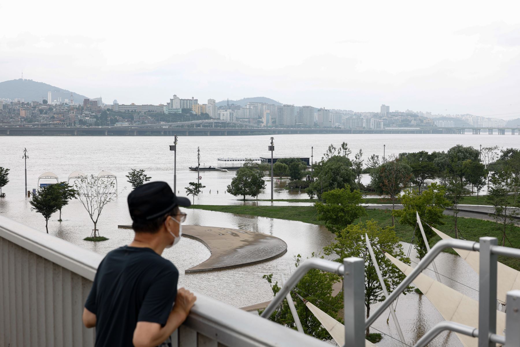 Un hombre mira desde el puente Jamsu sobre el río Han que desborda sus riberas en Seúl, Corea del Sur. Según los informes, al menos 13 personas han muerto y otras 13 desaparecieron después de que fuertes lluvias desencadenaran inundaciones y deslizamientos de lodo en el país.

Foto:EFE