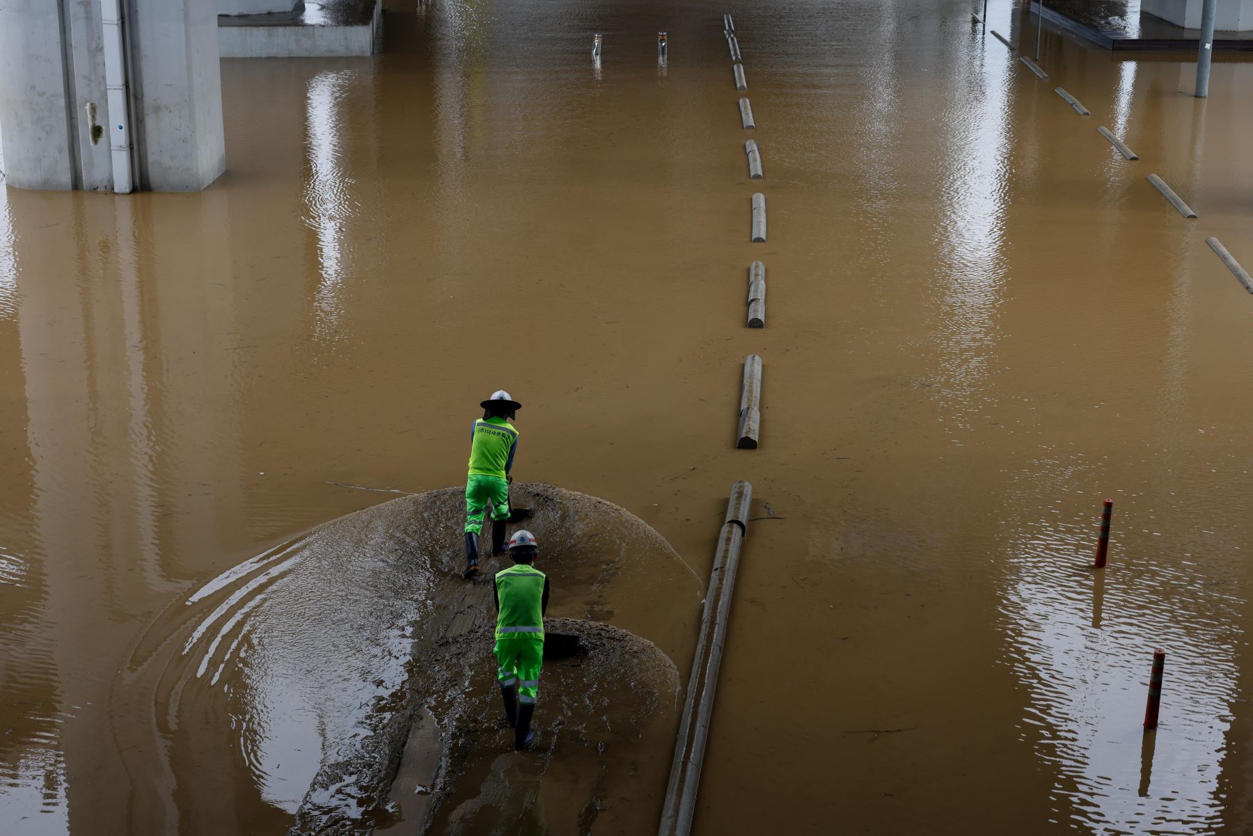 Trabajadores surcoreanos eliminan el lodo de una zona inundada debajo del puente Jamsu cerca del río Han en Seúl, Corea del Sur. Según los informes, al menos 13 personas murieron y otras 13 desaparecieron luego de que fuertes lluvias desencadenaran inundaciones y deslizamientos de lodo en el país. 

Foto:EFE