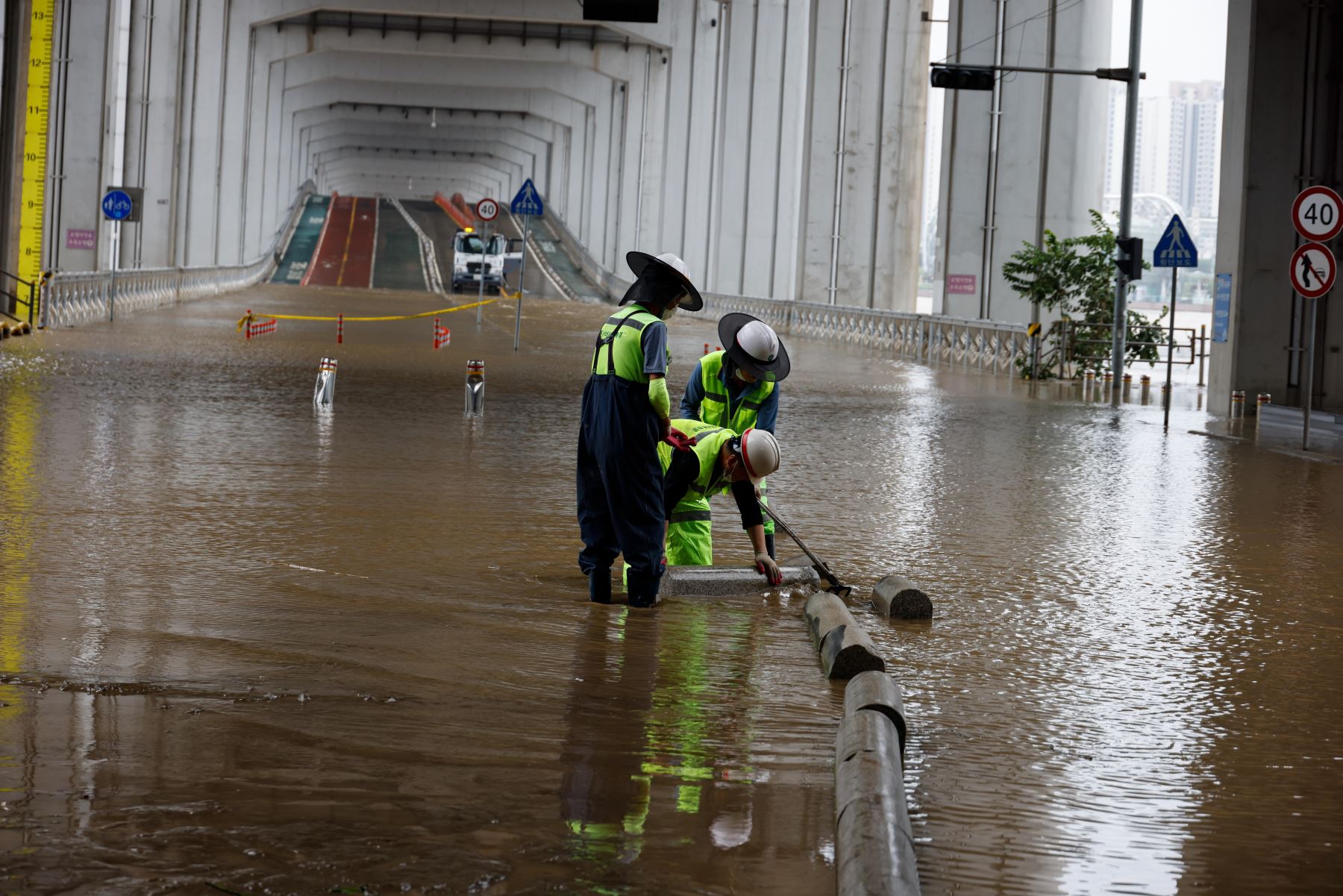 Trabajadores surcoreanos eliminan el lodo de una zona inundada debajo del puente Jamsu cerca del río Han en Seúl, Corea del Sur. Según los informes, al menos 13 personas murieron y otros 13 desaparecieron luego de que fuertes lluvias desencadenaran inundaciones y deslizamientos de lodo en el país. 

Foto: EFE