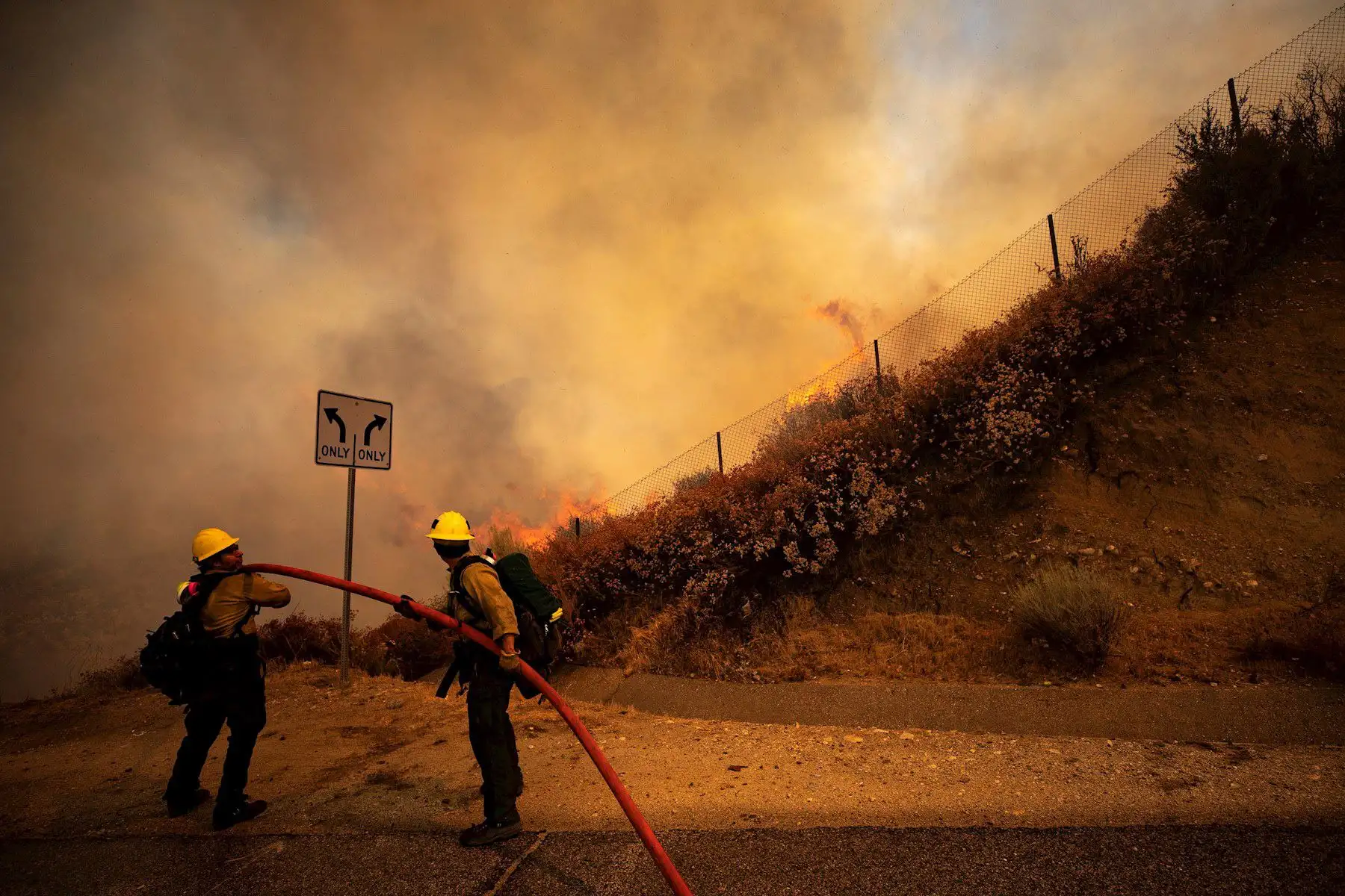 Dos bomberos intentan extinguir el incendio de Elsmere cerca de Santa Clarita, California, EE. UU. Según los últimos informes de los medios, el incendio ha quemado 130 acres. Foto: EFE
