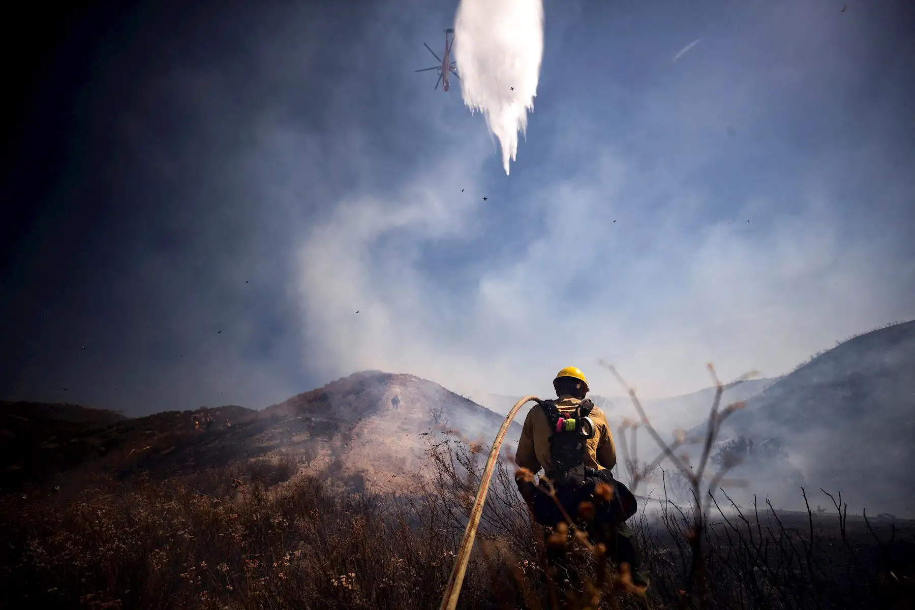 Bomberos intentan extinguir el incendio de Elsmere cerca de Santa Clarita, California, EE. UU. Según los últimos informes de los medios, el incendio ha quemado 130 acres. 

Foto: EFE