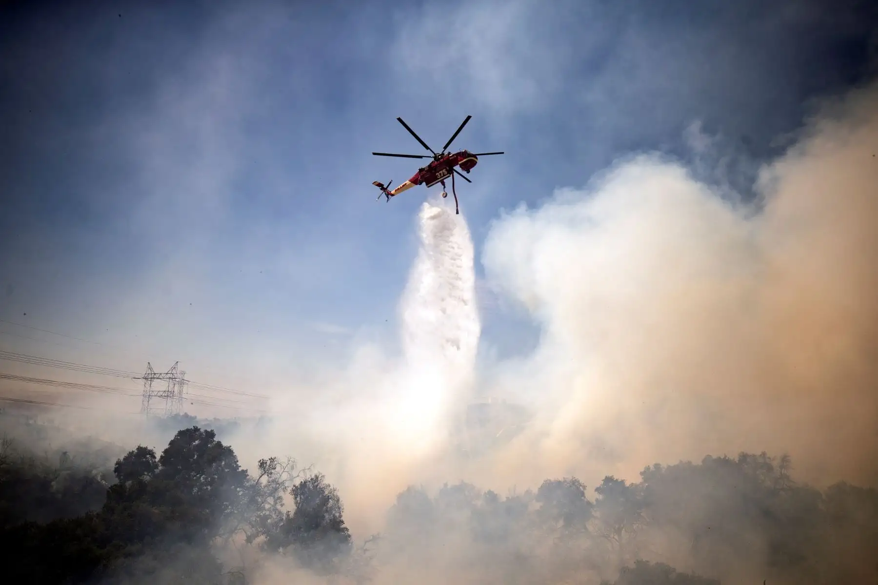 Un helicóptero arroja agua sobre el incendio de Elsmere cerca de Santa Clarita, California, EE. UU. Según los últimos informes de los medios, el incendio ha quemado 130 acres.

Foto: EFE