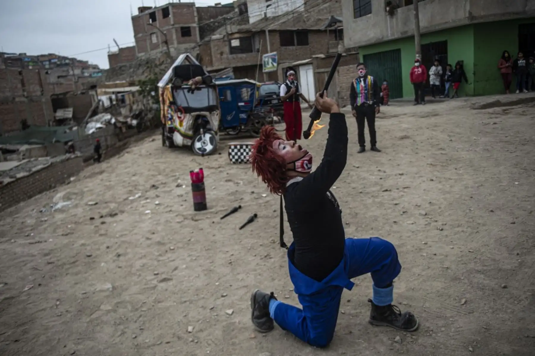 Un payaso actúa en el distrito de Puente Piedra, en las afueras del norte de Lima, durante la pandemia de covid-19. Debido a la pandemia de coronavirus, los circos en Perú permanecen cerrados, lo que lleva a este grupo de payasos que viajan en su circo mototaxi a actuar en las calles de Lima. 

Foto: AFP