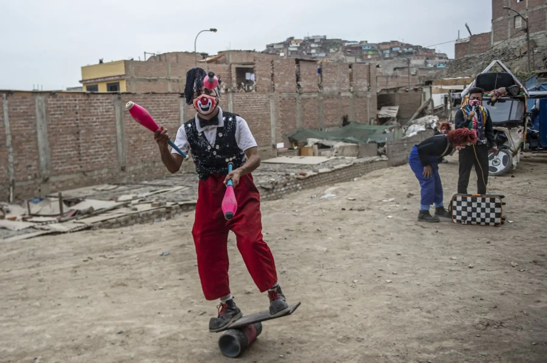 Un payaso con máscara facial actúa en el distrito de Puente Piedra, en las afueras del norte de Lima, durante la pandemia de covid-19.  Debido a la pandemia de coronavirus, los circos en Perú permanecen cerrados, lo que lleva a este grupo de payasos que viajan en su circo mototaxi a actuar en las calles de Lima. 

Foto: AFP