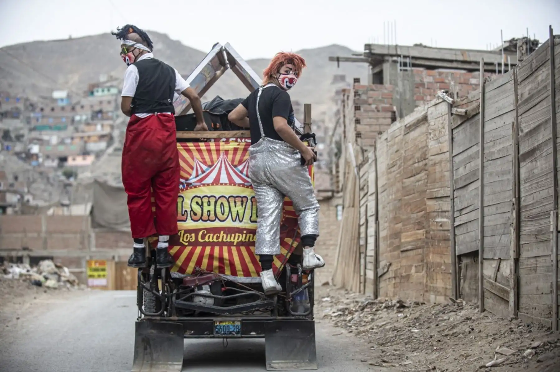 Los payasos con máscaras se presentan en el distrito de Puente Piedra, en las afueras del norte de Lima, durante la pandemia covid-19. - Debido a la pandemia de coronavirus, los circos en Perú permanecen cerrados, lo que lleva a este grupo de payasos que viajan en su circo mototaxi a actuar en las calles de Lima. 

Foto: AFP